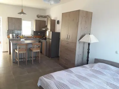 a kitchen with a bed and a table in a room at Cozy secluded studio with panoramic view in Áyios Yeóryios