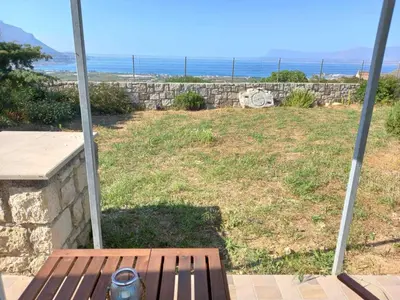 a bench on a porch with a view of the ocean at Cozy secluded studio with panoramic view in Áyios Yeóryios