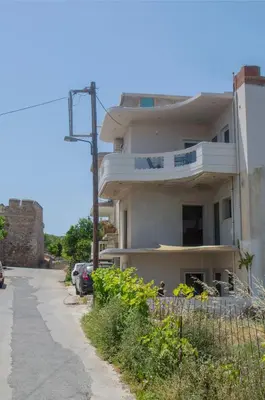 a white building with a balcony on the side of a street at Tonia's Apartment in Kissamos