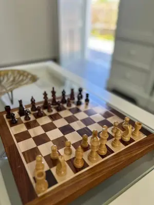 a wooden chess board with chess pieces on it at Chrisi Holiday Home - 500 sqm Private Gardens & Nature View - 300m by the sea in Almirida