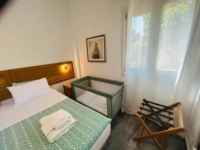 a bedroom with a bed and a window and a chair at Chrisi Holiday Home - 500 sqm Private Gardens & Nature View - 300m by the sea in Almirida