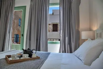 a bed with a tray with cups and a tea kettle on it at Old town, Splantzia modern house in Chania Town