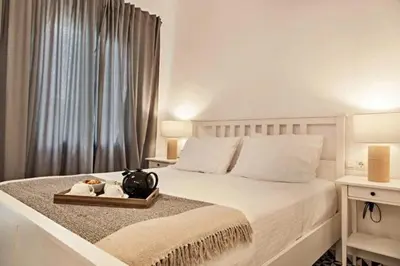 a bedroom with a white bed with a tray with towels at Old town, Splantzia modern house in Chania Town