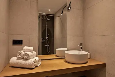 a bathroom with a sink and a shower with towels at Old town, Splantzia modern house in Chania Town