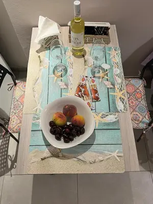 a table with a bowl of fruit and a bottle of wine at Marial City Apartment Chania in Chania Town