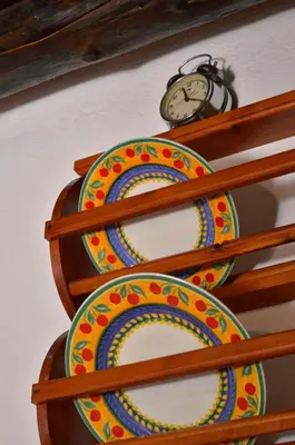 a clock sitting on top of a shelf with plates at Apanemia in Vamos