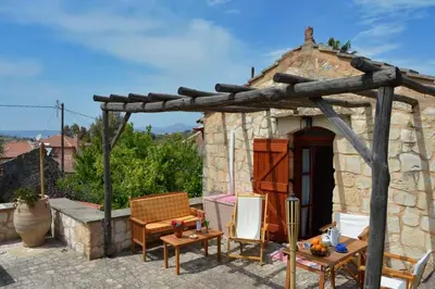 a stone house with a wooden pergola at Apanemia in Vamos
