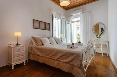 a white bedroom with a large bed and a window at Diogenis Residence Euphoria in Arménoi