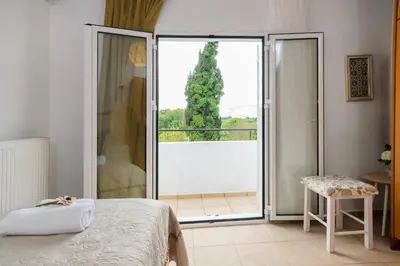 a bedroom with a bed and a sliding glass door at Diogenis Residence Euphoria in Arménoi