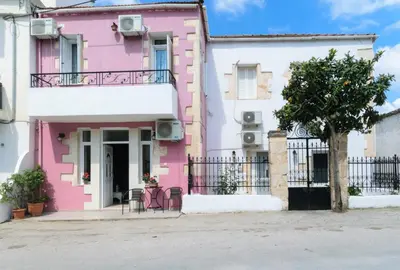 a pink house with a tree in front of it at Diogenis Residence Euphoria in Arménoi