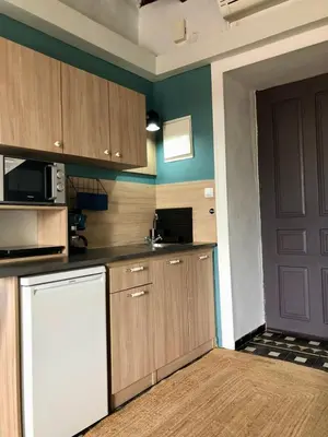 a kitchen with wooden cabinets and a black door at Old Port - Bellavista Studio in Chania Town