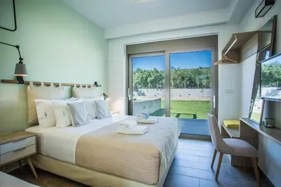 a bedroom with a large bed and a large window at Villa Aori in Kariá