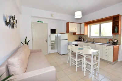 a kitchen and living room with a couch and a table at Endless Blue in Palaiochóra