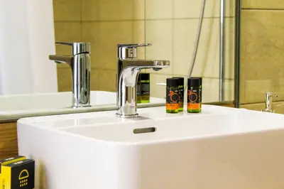 a bathroom sink with a faucet and two products on it at Endless Blue in Palaiochóra