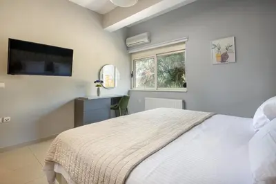 a white bedroom with a bed and a window at Queen Electra with pool and tennis court in Alikianós