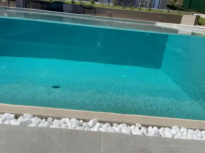 a swimming pool with rocks next to the water at Twins Apartments in Plataniás