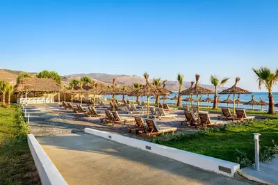 a row of chairs and umbrellas at a beach at Solimar White Pearl - Adults Only in Kolymvari