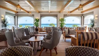 a room with chairs and tables and windows at Solimar White Pearl - Adults Only in Kolymvari