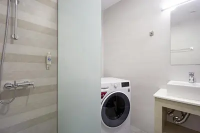 a bathroom with a washing machine and a sink at Alexandra Apartment in Daratso