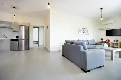 a living room with a couch and a kitchen at Alexandra Apartment in Daratso