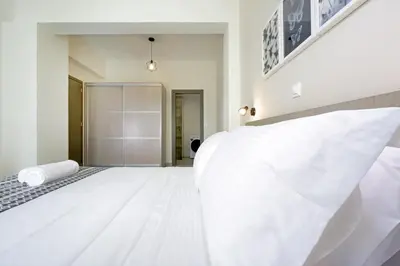 a white bedroom with a large white bed at Alexandra Apartment in Daratso