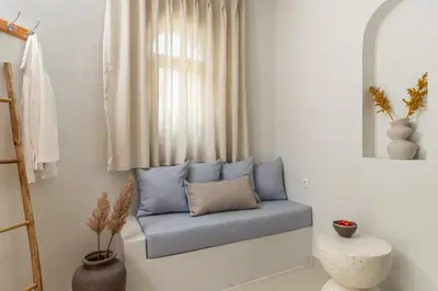 a blue bench in a room with a window at Fata Morgana Studios & Apartments in Frangokastello