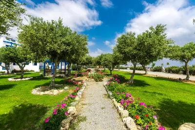 a garden with flowers and trees in a park at Fata Morgana Studios & Apartments in Frangokastello