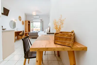 a dining room and living room with a wooden table at Koulouris Apartments & Studios in Kalyves
