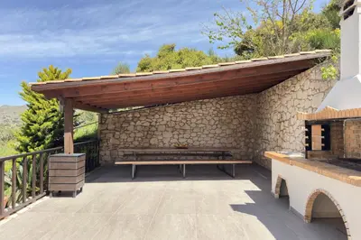 a wooden pergola with a bench on a patio at YaChara Villa in Kissamos