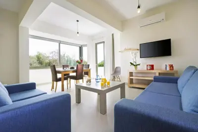 a living room with two blue couches and a table at Ellie Apartment in Daratso