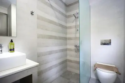 a bathroom with a shower and a toilet and a sink at Ellie Apartment in Daratso