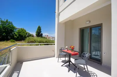 a balcony with a red table and chairs at Ellie Apartment in Daratso