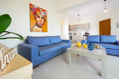 a living room with two blue couches and a table at Ellie Apartment in Daratso