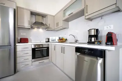 a kitchen with white cabinets and stainless steel appliances at Ellie Apartment in Daratso