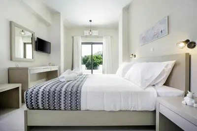 a bedroom with a large white bed and a window at Ellie Apartment in Daratso