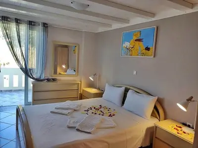 a bedroom with a large bed with two towels on it at House just on the beach -included 2 canoe and 2 bicycles in Ravdhoúkha