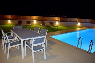 a table and chairs next to a swimming pool at Balos Residence private pool Seafront Seaview in Kissamos
