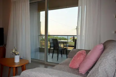 a living room with a couch with pink pillows at Balos Residence private pool Seafront Seaview in Kissamos