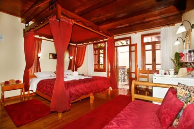 a bedroom with a canopy bed with red curtains at Palazzo di Pietro in Chania Town