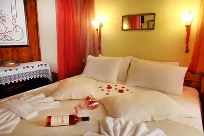a bed with a bottle of wine and flowers on it at Palazzo di Pietro in Chania Town