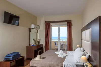 a hotel room with a bed and a view of the ocean at Eurohotel Theo Hotel in Agia Marina Nea Kydonias