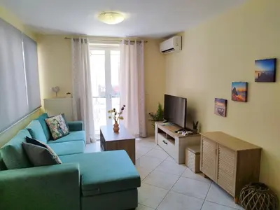 a living room with a blue couch and a television at Marias Apartment in Chania Town
