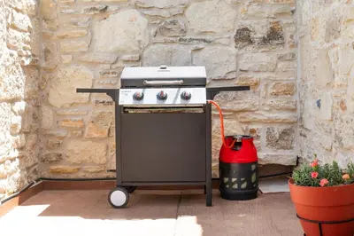 a stove with a red bucket next to a stone wall at Dream Sea House villa Falassarna in Falasarna