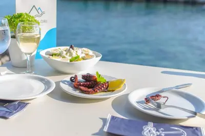 a table with plates of food and a glass of wine at Lefka Ori in Khóra Sfakíon