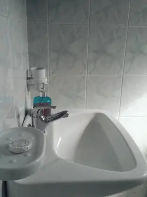 a bathroom sink with a soap dispenser on top of it at CAPTAIN GEORGE in Sougia