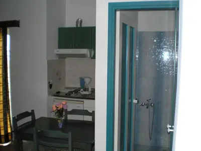 a kitchen and a dining room with a table and a kitchen at CAPTAIN GEORGE in Sougia