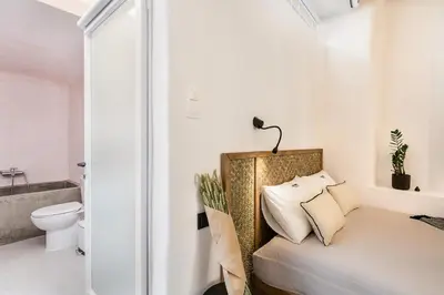 a small bedroom with a bed and a toilet at Artemide city places-Cozy Rooms in Chania Town