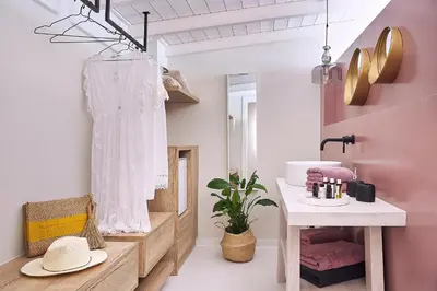 a bathroom with pink walls and a sink and a mirror at Villa Niolos II in Stérnai