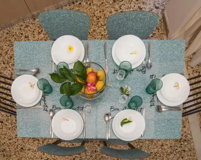a table with white plates and a bowl of fruit at The Romantic Beach House in Chania Town