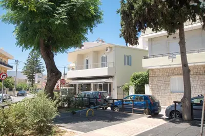 a building with cars parked in a parking lot at The Romantic Beach House in Chania Town